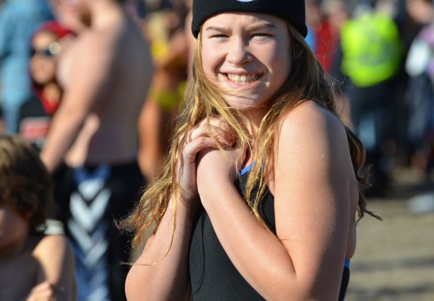 people participating in the 12th annual polar bear dip at Sunnyside Park in Toronto, in the icy cold water of Lake Ontario