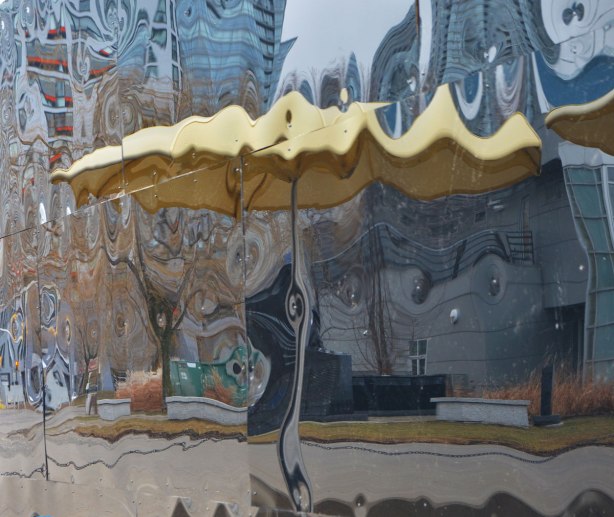 reflections of the yellow umbrellas of H T O beach on the black shiny sides of Icebox, an art installation at the beach 