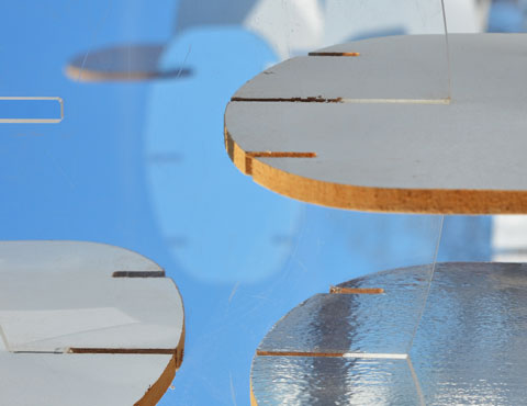  close up photo of part of an artwork made of wooden oval shapes that are notched together. 