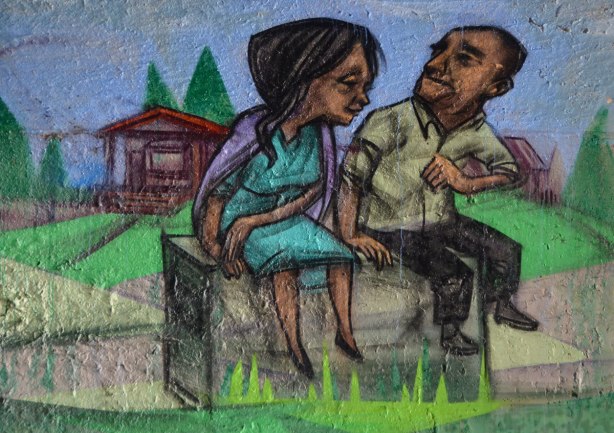 mural by elicser in the tunnel that is a railway underpass - a couple sits on a bench, a cabin is behind them 