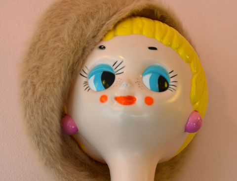 mannequin head, bright yellow short hair, blue eyes, red lips, pink ears, big smile on her face, wearing a beige tam