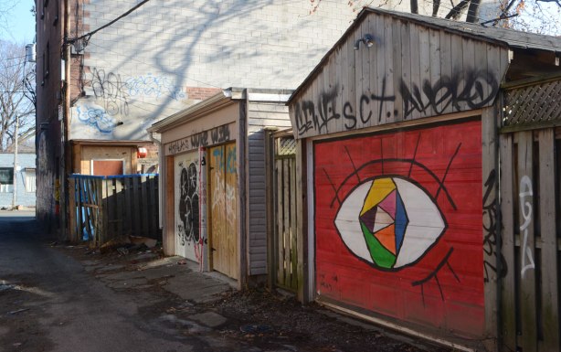 garage door painted bright red with a multicoloured eye (large) in the middle 