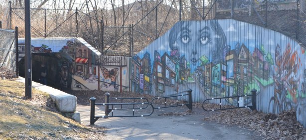 a long mural by elicser that leads from Monarch Park, through the railway underpass and to the community garden on the other side, pictures of people 