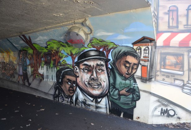 mural by elicser in the tunnel that is a railway underpass - people walking outside