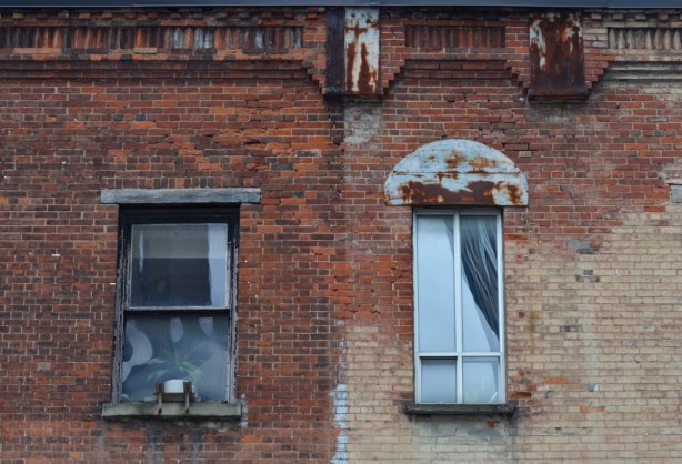 an old brick building with two windows. 