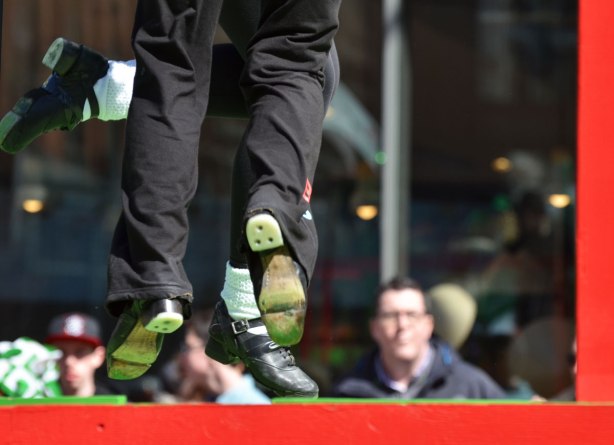 feet and legs of two girls dancing on a float in a parade
