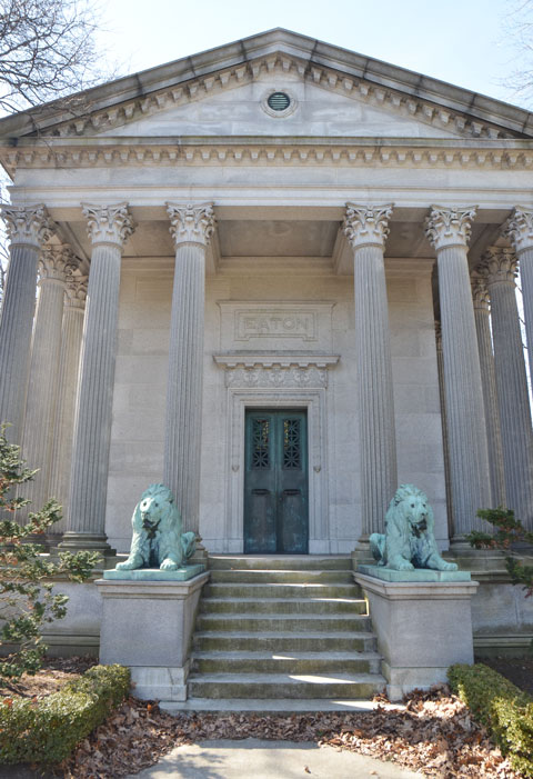 entrance to Eaton tomb/vault at Mt. Pleasant cemetery, two lions beside the steps that lead to the metal door, large corninthian columns on either side of the door. 