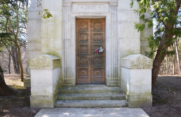 front of cemetery tomb for Just family, wood door with engravings on it. 