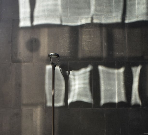 light reflecting off a glass building and landing on a black wall on the building beside it