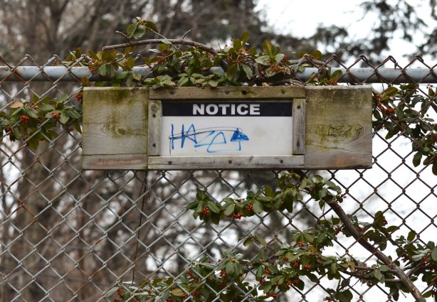 a sign on a chainlink fence that says notice. otherwise it is blank