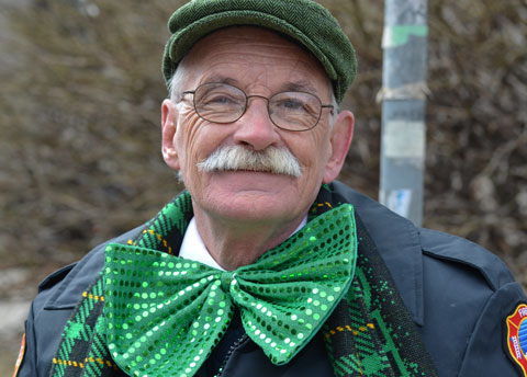 a retired fireman with a green tam, moustanche and a big green bowtie