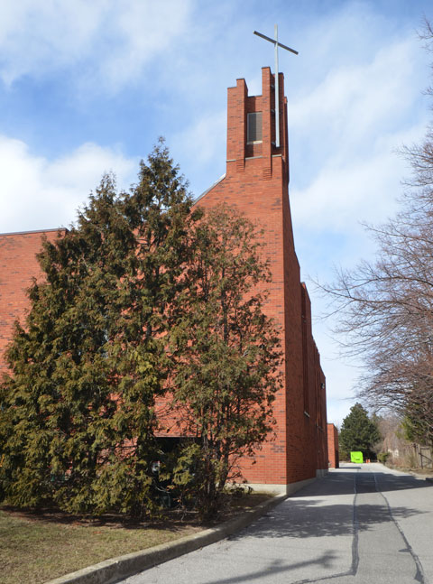 steeple of St. Elizabeth of HUngary RC church, modern brick building with simple cross on the top