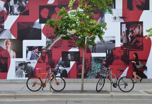 bikes parked in front of a large poster advertising TIFF's Canada on Screen program, a collage of black and white pictures taken from movies. 