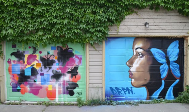 a mural on a garage door in an alley, part of butterflyways project - two adjacent garage doors, the left one is width=