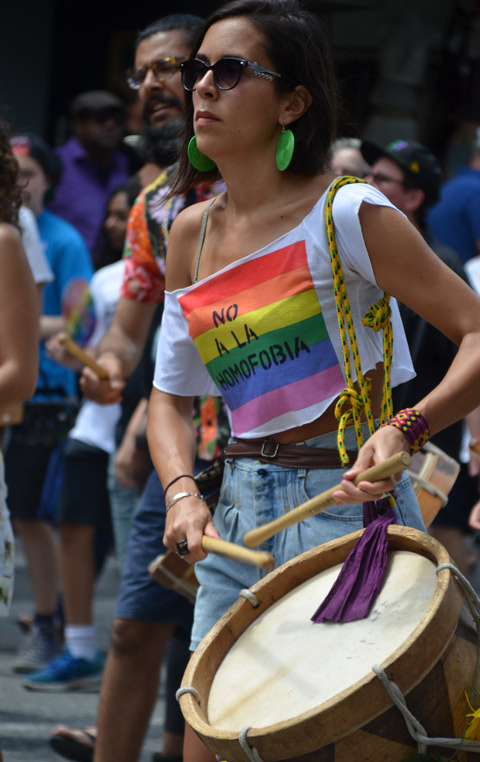 a woman drummer, She is wearing a tshirt that says no a la homofobia. walking in dyke march