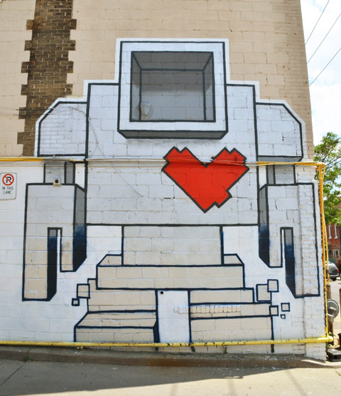 large lovebot, two storeys high, painted on the side of a building. 