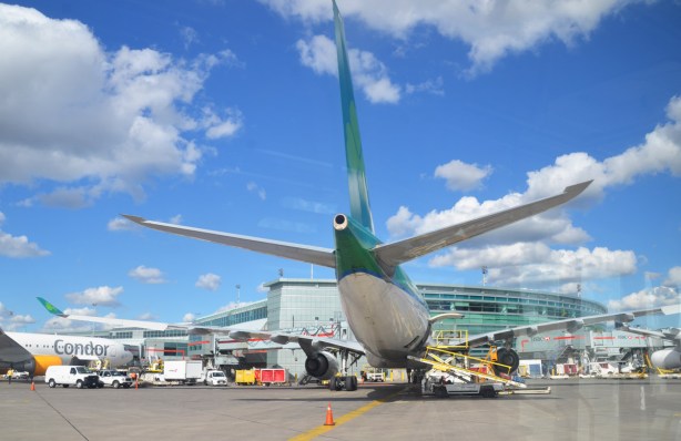 view of a large airplane from the back, parked at a gate at airport