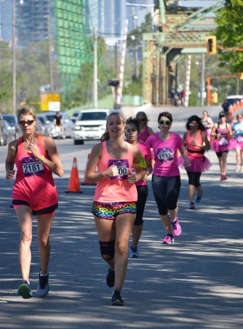 a group of women running on Cherry St in the Port Lands as part of the Run Like a Diva 5k run. 