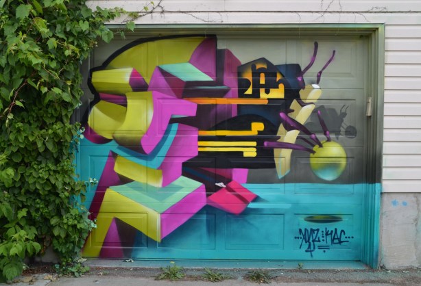 a mural on a garage door in an alley, part of butterfly ways project - very stylized abstract picture of a butterfly and a flower