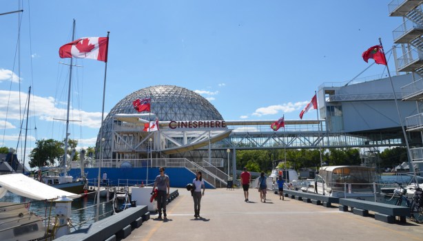 flags line the walkway leading from the dome shaped cinesphere at Ontario Place, 