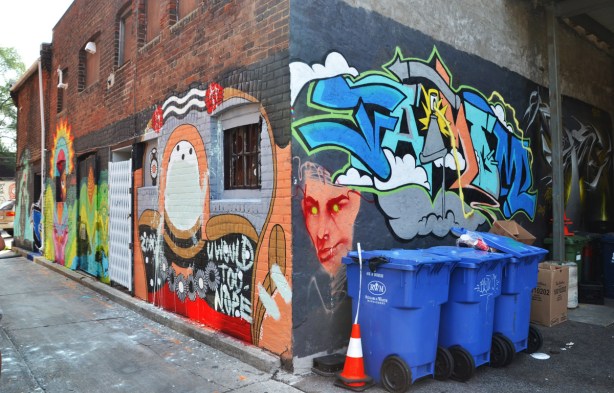 corner of a building in a lane showing the street art on two sides 