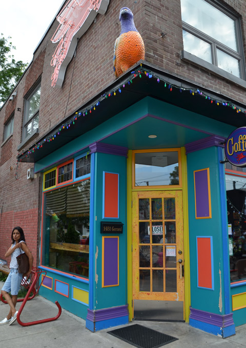 front entrance of the Flying Pony coffee shop, bright blue door frame, yellow door, orange and purple squares on the door frame
