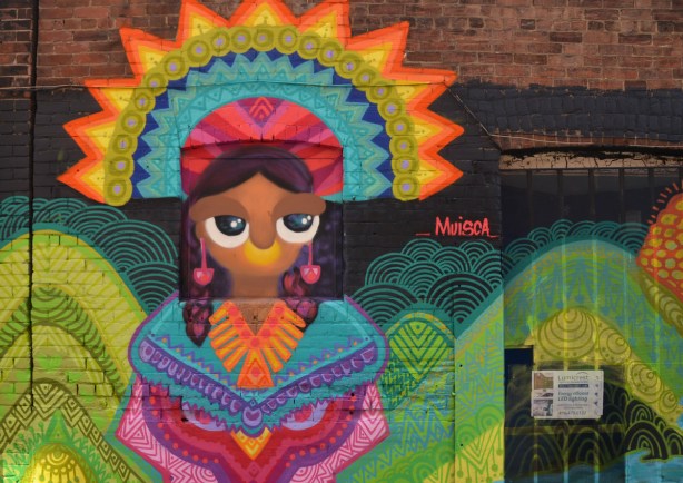 Spanish or South American themed woman with large sun shaped headdress and colourful dress by muisca