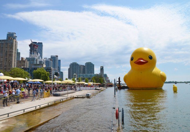 large inflatable yellow rubber duckie sits on the water, Lake Ontario, at the waterfront in Toronto