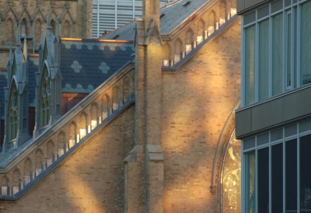 close up of part of a church roof and window with reflected light on it. 