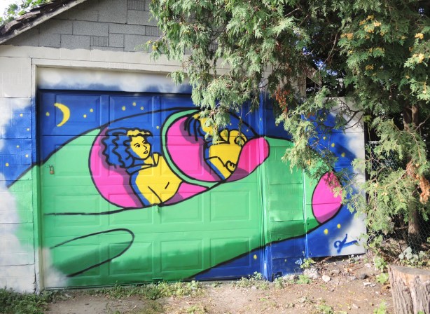 on a garage door, a painting by Kim, blue background, close up of two yellow women pilots in a green airplane 