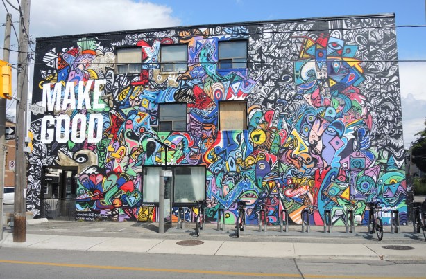 large colourful mural by J. Chiale on the side of a building. Large white letters that say Make Good. 
