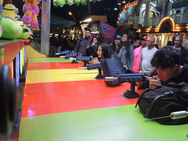 young man concentrating as he shoots water into a target at a game at the CNE