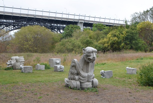 a few concrete gargoyles scattered on the ground by the Lower Don Trail, part of Duane Linklater's art installation. 