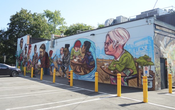 mural by elicser of people - whole mural, completed, on Barbara Barrett Lane, musicians and the people listening to them as they sit at tables