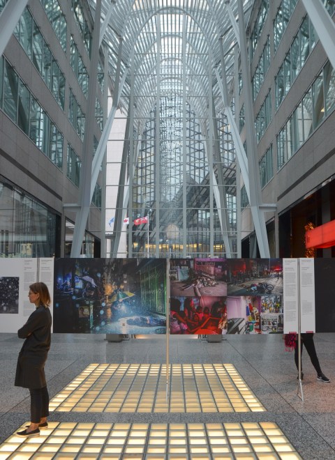 glass ceiling of the Alan Lambert Galleria in Brookfield place with the world press photo exhibit underway, people looking at the posters 