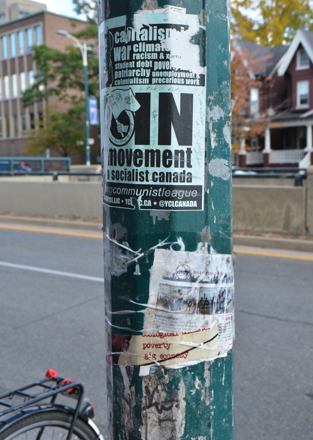 old posters on a a green utility pole, Join the socialist movement in Canada, gig economy,