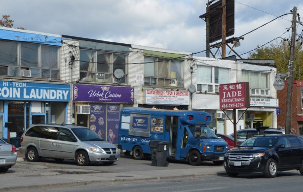 a blue food truck is parked in front of the Taj Restaurant, an Uzbek restaurant 