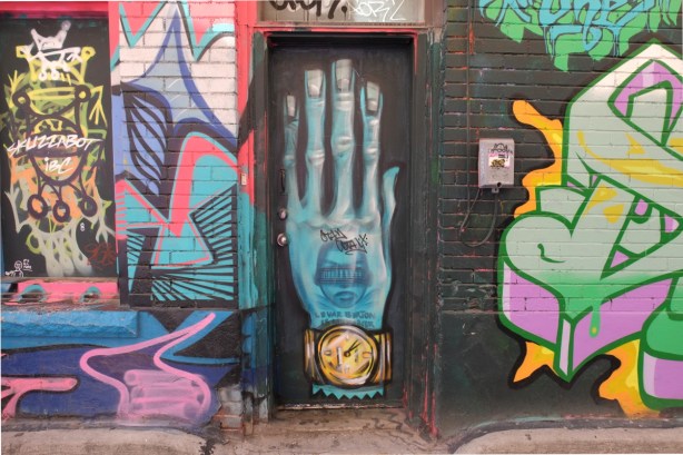 mural in Graffiti Alley - a large blue hand the size of a door, with watch on wrist and words Levar Burton 