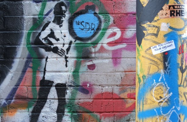 stencil graffiti of a person in white coat 