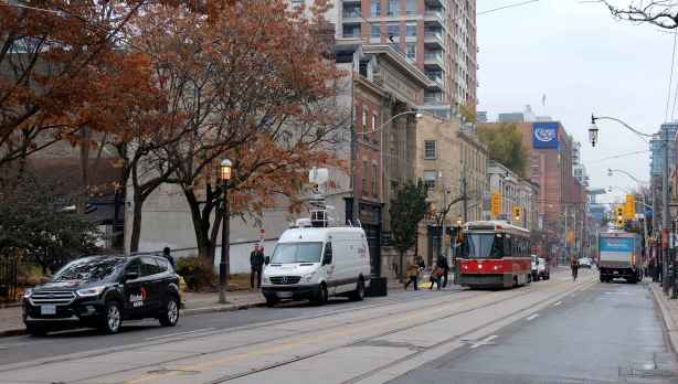 Global TV car and truck parked on King street, street car about to pass them
