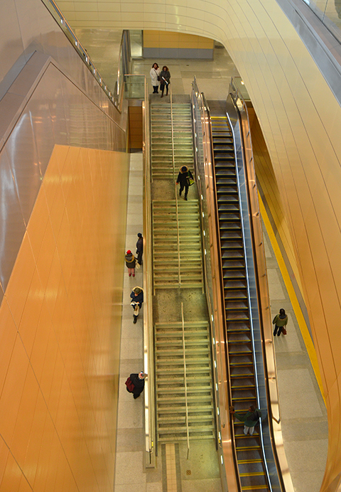 looking down two levels of the new Downsview Park subway station, long escalator and flight of stairs