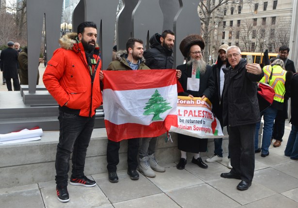 protest at Trumps decision to recognize Jerusalem as capital of Israel, University Ave. A group is gathered around a man holding a Lebanese flag. 