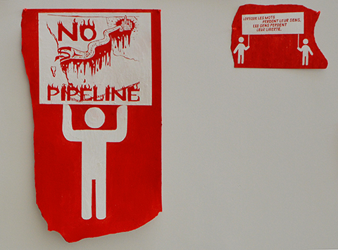 red and white paintings of demonstration signs being held by stick figure men part of an art exhibit at fleck conservatory - sign says no pipeline