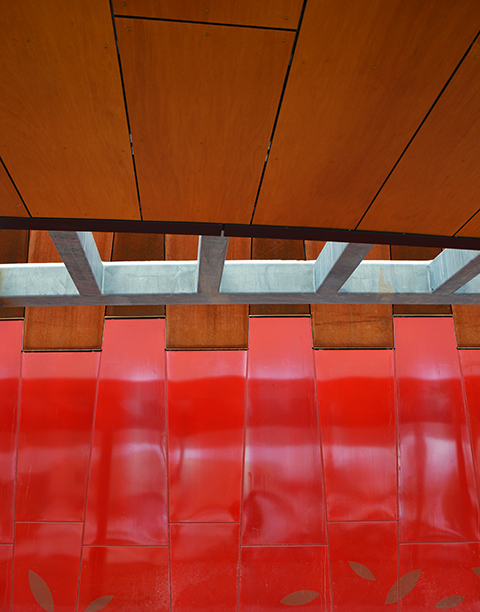 abstract of the exterior walls of Pioneer Village subway station, red panels with wood roof and grey steel beams