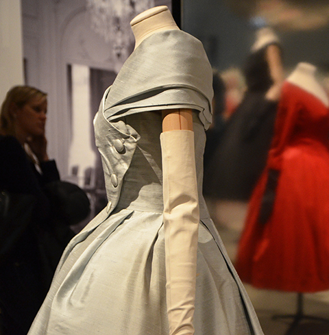 pale blue grey silk Christian Dior dress in the background, a red and a black dress are in the background, ROM exhibit, 