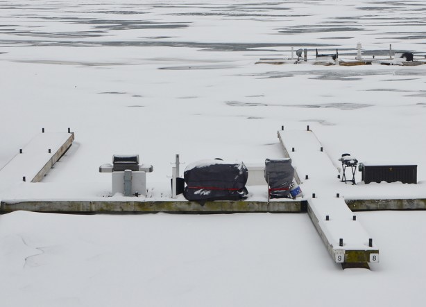 barbecues under tarps on snow covered docks in partially frozen harbour