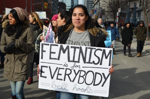 Toronto womens march and protest, a young woman with a sign that says feminism is for everybody 