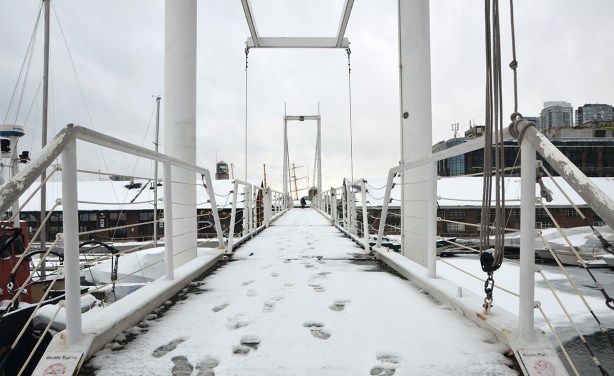 a few footprints in the snow on a bridge 