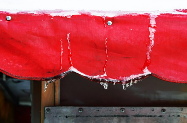 scalloped edged awning, in winter, with snow on the top and some froze drips of water and icicles 