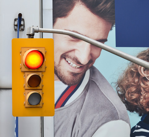 traffic signal, red light, in front of a billboard with a father and child